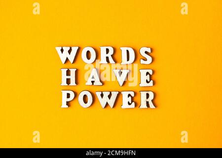 Quote WORDS HAVE POWER made out of wooden letters on bright yellow background. Stock Photo