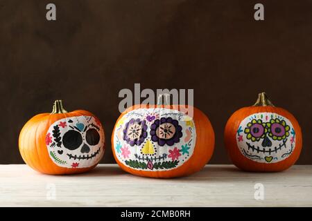 Pumpkins with catrina skull makeup on brown background Stock Photo
