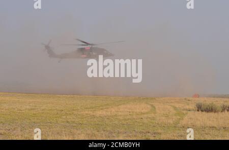 An Oregon Army Guard HH-60M Black Hawk helicopter lands after first setting its attached water bucket on the ground at the Brattain Helibase on September 15, 2020 at the Brattain Helibase, near Lakeview, Ore for refueling. Two Oregon Guard Black Hawks, headquartered out of Salem, Ore. are currently assigned to the fire. The helicopters concentrated on dumping water buckets on the north perimeter of the fire in coordination with other aircraft supporting wildland firefighting efforts. The Brattain Fire started on September 7, 2020. (National Guard photo by Maj. Leslie Reed, Oregon Military Depa Stock Photo