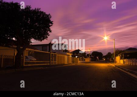 Road running through suburban neighborhood houses at sunrise, Cape Town, South Africa Stock Photo