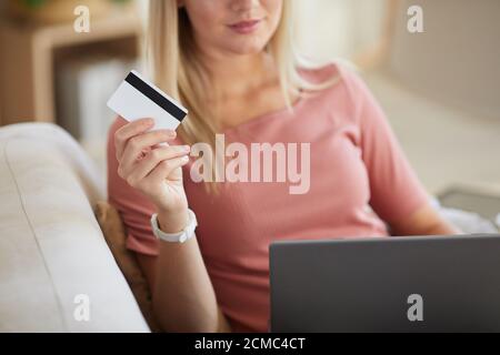 Close-up of young woman holding credit card she paying online using her laptop Stock Photo