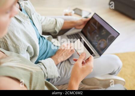 Close-up of couple holding credit card and paying for delivery of food online while using laptop at home Stock Photo