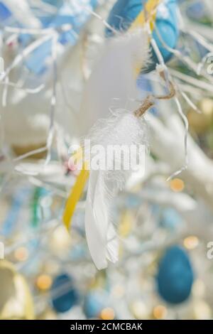 colorfull easter egg tree. brights eggs and tender feathers hanging from branches. Stock Photo