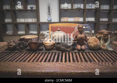 Tea god figurines and teaware on tea board. Traditional chinese tea ceremony Stock Photo