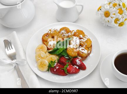 French toast with syrup and a banana with powdered sugar Stock Photo