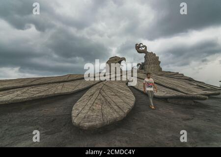 KOLLAM, INDIA - Sep 11, 2019: An Indian Male walking next to the World's Largest Eagle Statue named Jatayu located in Kollam, Kerala Stock Photo