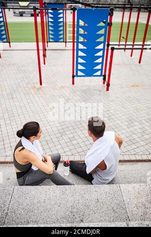 Young couple relaxing after training on sports ground Stock Photo