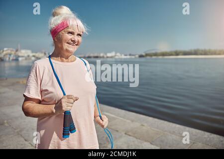 Smiling pleased elderly lady standing on the quay Stock Photo