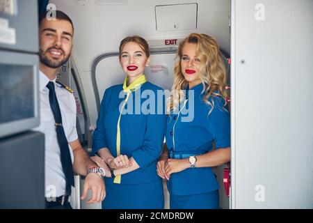 Beautiful air hostess with captain on the board of aircraft Stock Photo