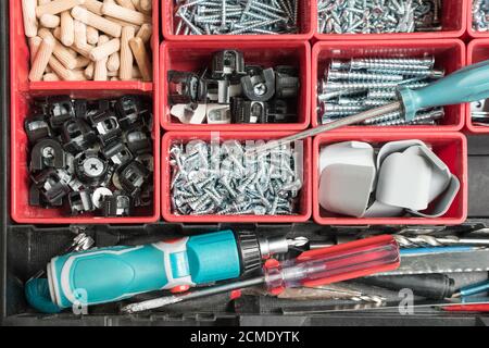 Toolbox with different instruments. Screws and screwdriver Plactic box with tools. Furniture assembly and renovation work concept Stock Photo