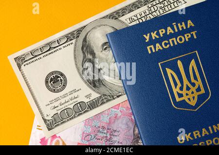 Ukrainian citizen passport with US dollars and Ukrainian hryvnia banknotes inside. Going abroad, exchange rate concept Stock Photo