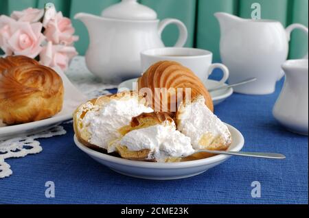 Eclairs close-up on a plate with a cup of coffee Stock Photo