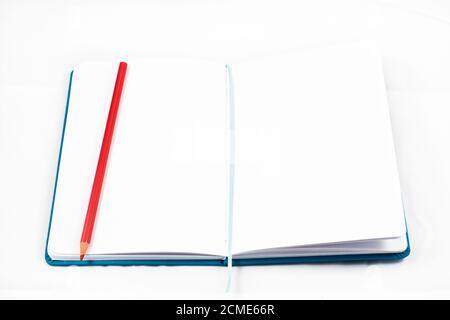 top view of an open notebook to take notes with red pencil on white background. design concept Stock Photo