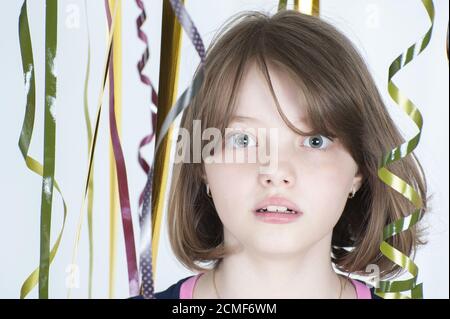 Portrait of a girl among the multicolored confetti. Stock Photo