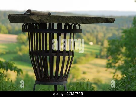 Empty portable BBQ grill in front of a fresh green summer landscape, colse-up Stock Photo