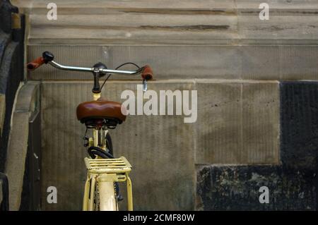 details of old yellow bicycle. leather seat with shock absorbers and wheel Stock Photo