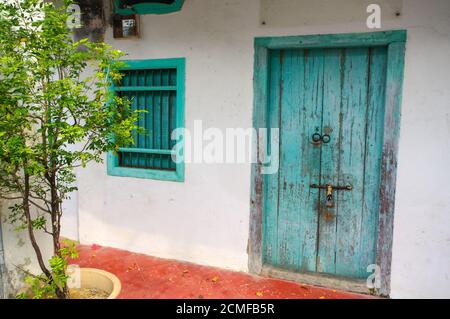 House in George Town, Penang, Malaysia. Mediterranean style exterior. Blue wooden doors and window shutters on old painted wall Stock Photo