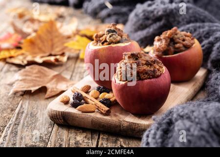 Stuffed apples baked with nuts on wooden table Stock Photo