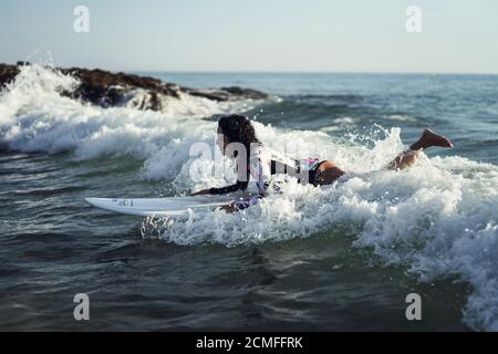 Beautiful young surfer woman  with a surfboard having fun on the beach Stock Photo