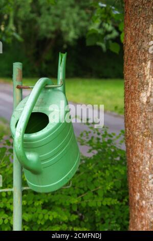 watering can hanging on faucet, gardening, summer. Stock Photo