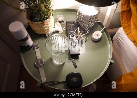 Bedside table nightstand with lamp and other typical items Stock Photo