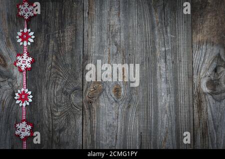 Red ribbon with decorative snowflakes on gray wooden background Stock Photo