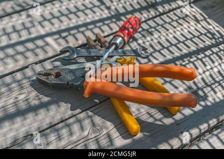 Heap of working tools, pliers, screwdrivers and wrenches on a wooden table Stock Photo