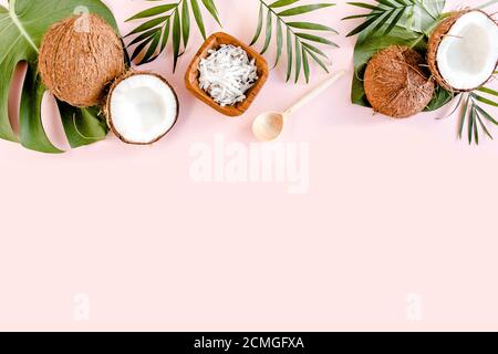 Pattern with coconuts and tropical palm leaves on pink background. Tropical abstract background. Flat lay, top view. Stock Photo