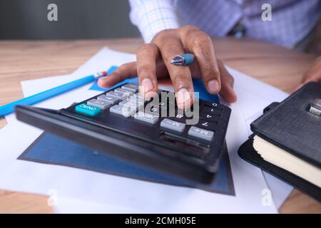 close up of businessman using calculator on office desk  Stock Photo