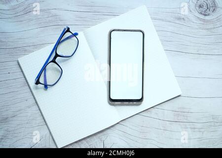 flat composition of smart phone and notepad on table  Stock Photo