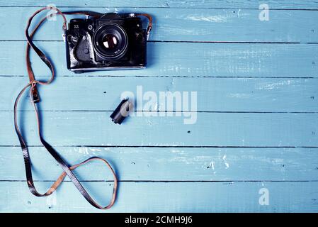 Vintage film camera in a leather case on a blue wooden surface Stock Photo