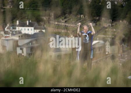 Edinburgh, Scotland, UK. 17 September 2020. Pictured: Sean Clerkin of Action For Scotland seen above the Scottish Parliament at Holyrood, Edinburgh, and burns the Union Jack Flag in a defiant act fighting for Scottish independence. Credit: Colin Fisher/Alamy Live News. Stock Photo