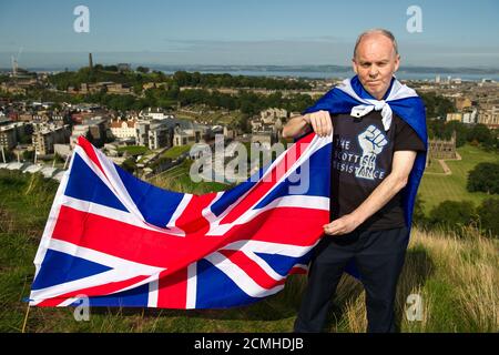 Edinburgh, Scotland, UK. 17 September 2020. Pictured: Sean Clerkin of Action For Scotland seen above the Scottish Parliament at Holyrood, Edinburgh, and burns the Union Jack Flag in a defiant act fighting for Scottish independence. Credit: Colin Fisher/Alamy Live News. Stock Photo