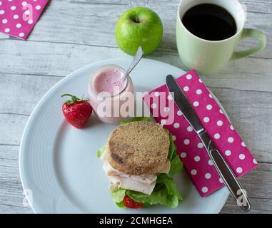 Healthy breakfast sandwich with yogurt served on a white plate on wooden background Stock Photo