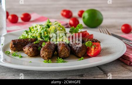 spicy minced meat rolls with salad on a plate Stock Photo