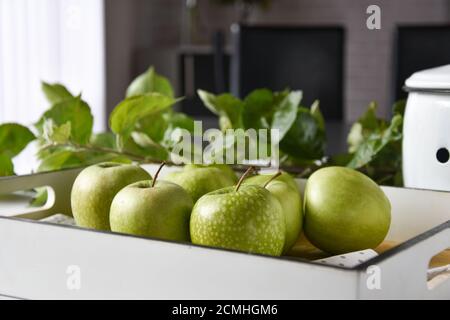 green apples on a wooden tray served on a table at home Stock Photo