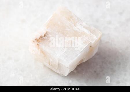 closeup of sample of natural mineral from geological collection - unpolished Calcite rock on white marble background Stock Photo