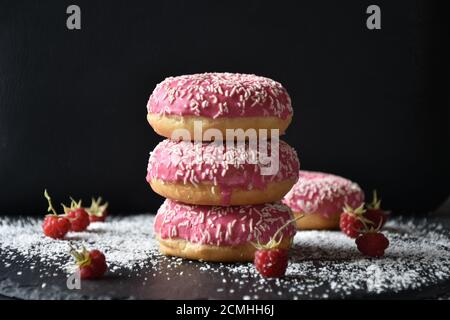 a Stack with pink donuts on dark background Stock Photo