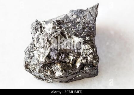 closeup of sample of natural mineral from geological collection - unpolished bituminous coal (black coal) on white marble background from Ukraine Stock Photo