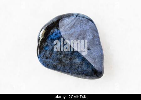 closeup of sample of natural mineral from geological collection - polished Dumortierite rock on white marble background from Mozambique Stock Photo