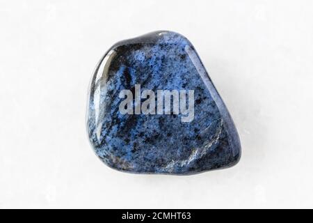 closeup of sample of natural mineral from geological collection - tumbled Dumortierite rock on white marble background from Mozambique Stock Photo