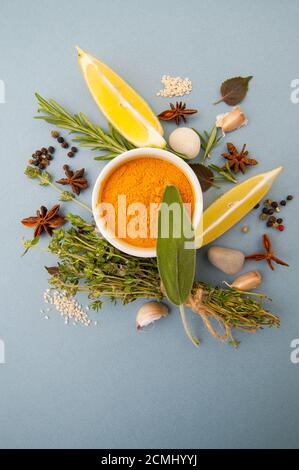 Various dried and spices and fresh seasonings on a gray table. Stock Photo