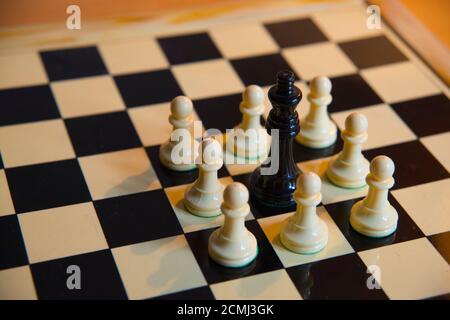 Chess. Black queen surrounded by white pawns. Stock Photo