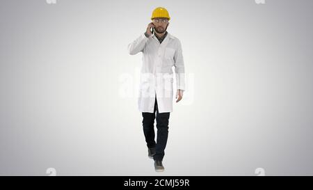 Confident male engineer wearing helmet on call on gradient backg Stock Photo