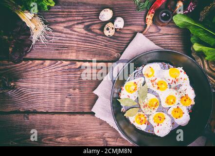 Fried quail eggs in a cast-iron frying pan Stock Photo