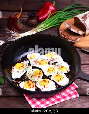 Fried eggs in a black cast-iron frying pan Stock Photo