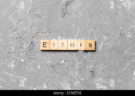 Errors word written on wood block. Errors text on cement table for your desing, concept. Stock Photo