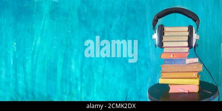 large heap of books and vintage headphones,audio book concept, panoramic with large copy space Stock Photo
