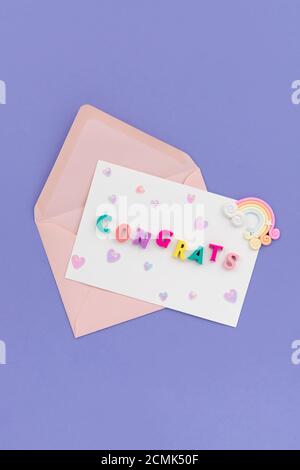 Open pink envelope with the word congrats on violet background Stock Photo