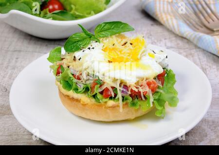 Sandwich with vegetable filling and egg poached, sprinkled cheese Stock Photo